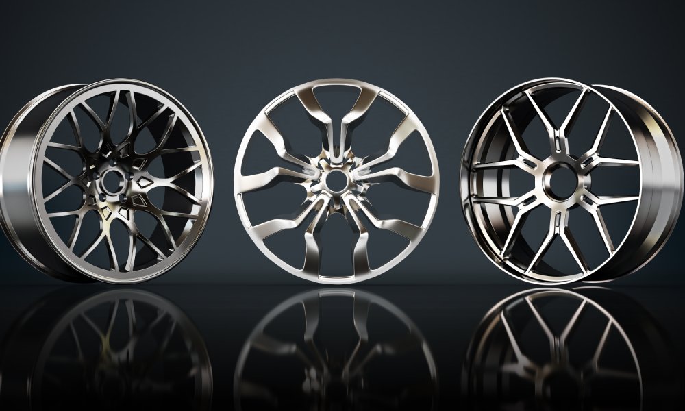 A set of three new car rims of various materials and rim designs displayed vertically against a black background.